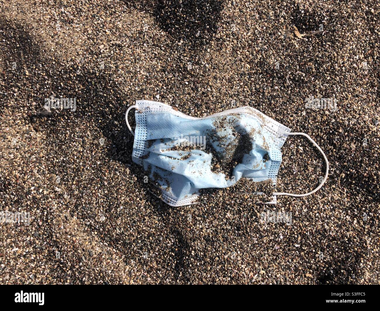 Facemask causing pollution on the beach - Smartphone Captured Stock Image