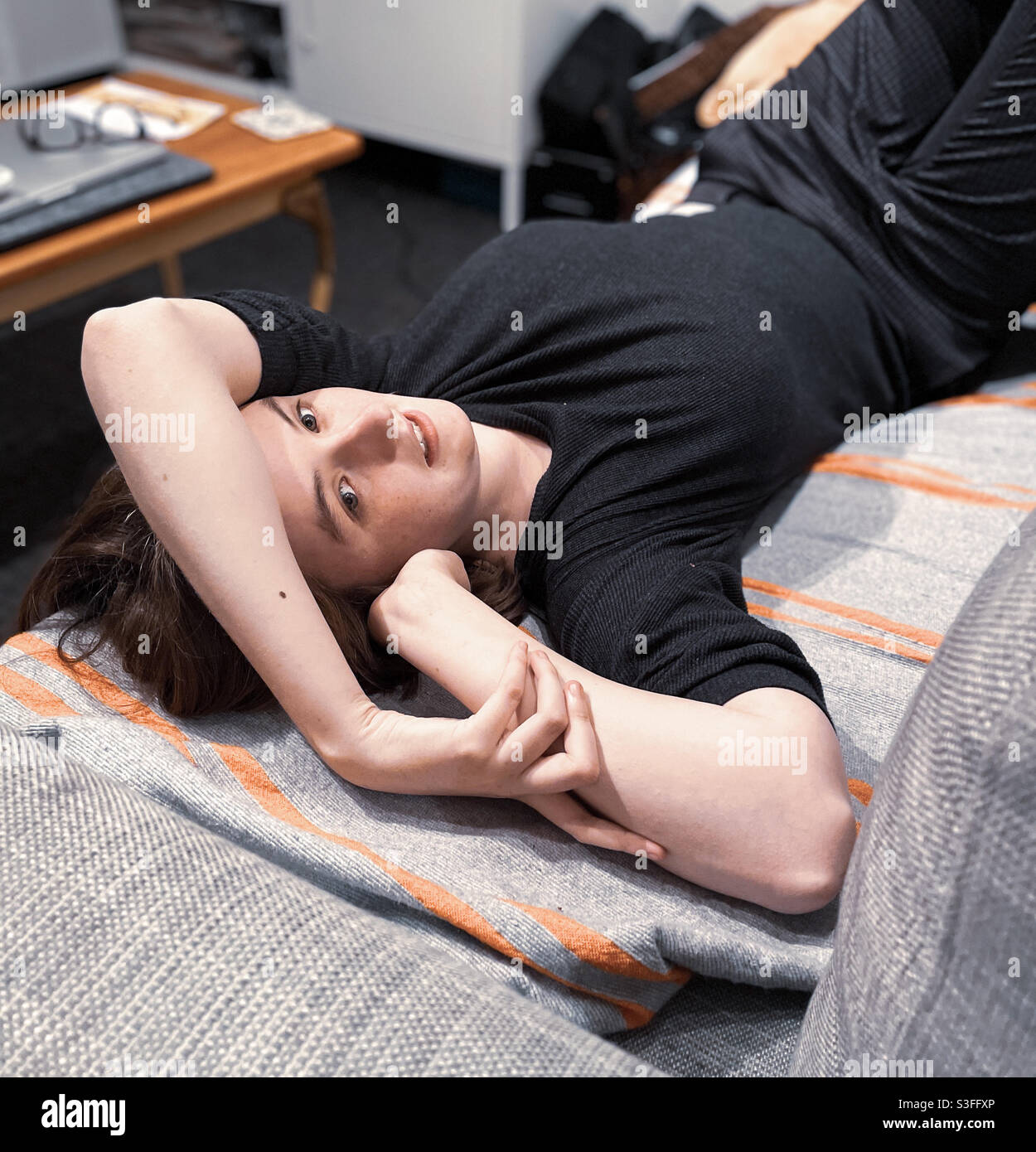 Thoughtful young women lying on couch - Smartphone Captured Stock Image