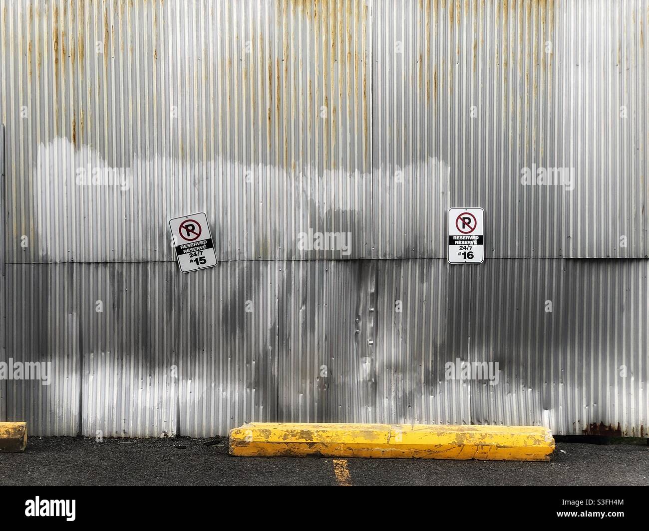 Private parking lot by the corrugated metal wall in Ottawa, Canada, 2021 - Smartphone Captured Stock Image