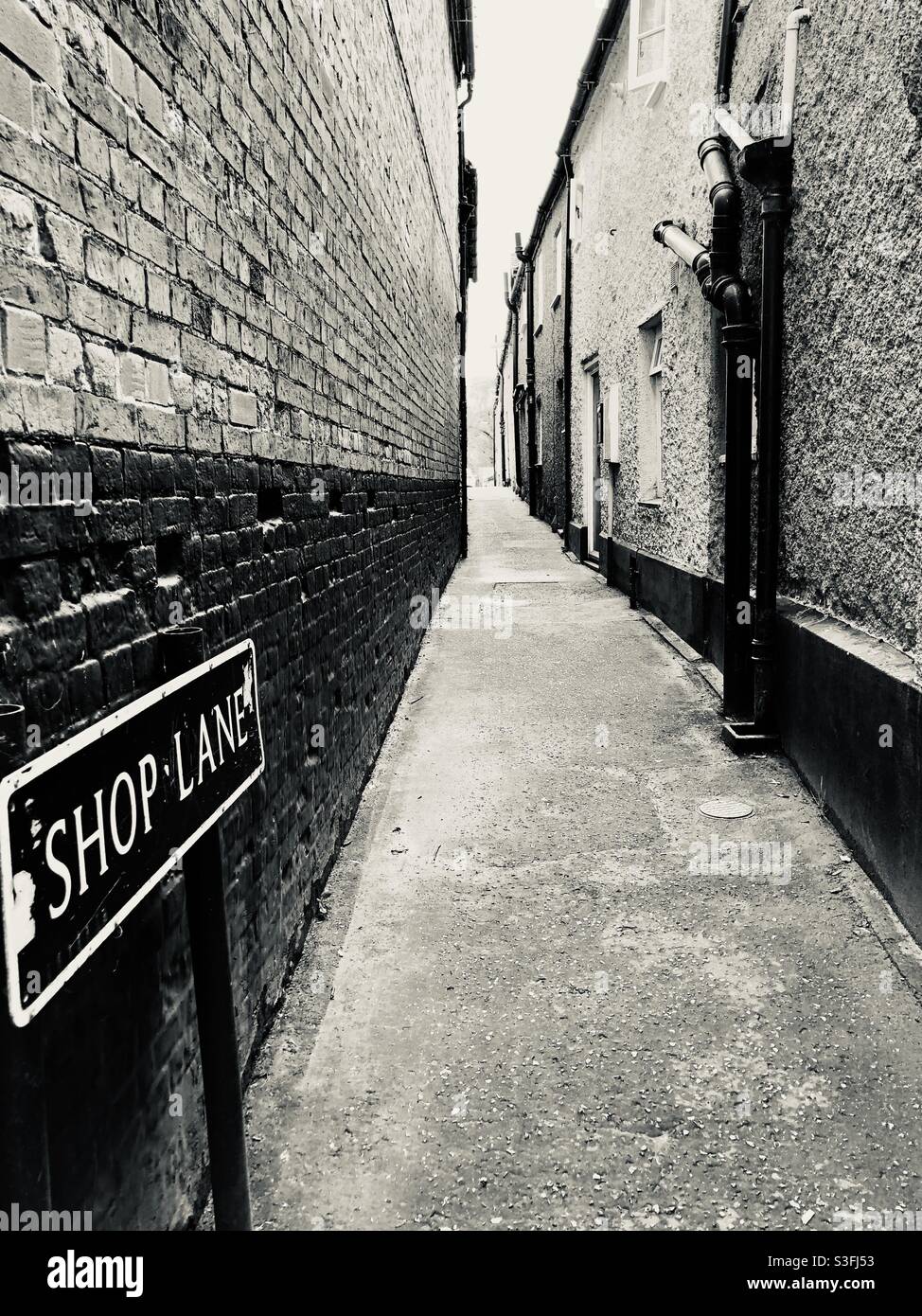 Shop Lane - a narrow alley in Wells-next-the-sea shown here in black and white Stock Photo