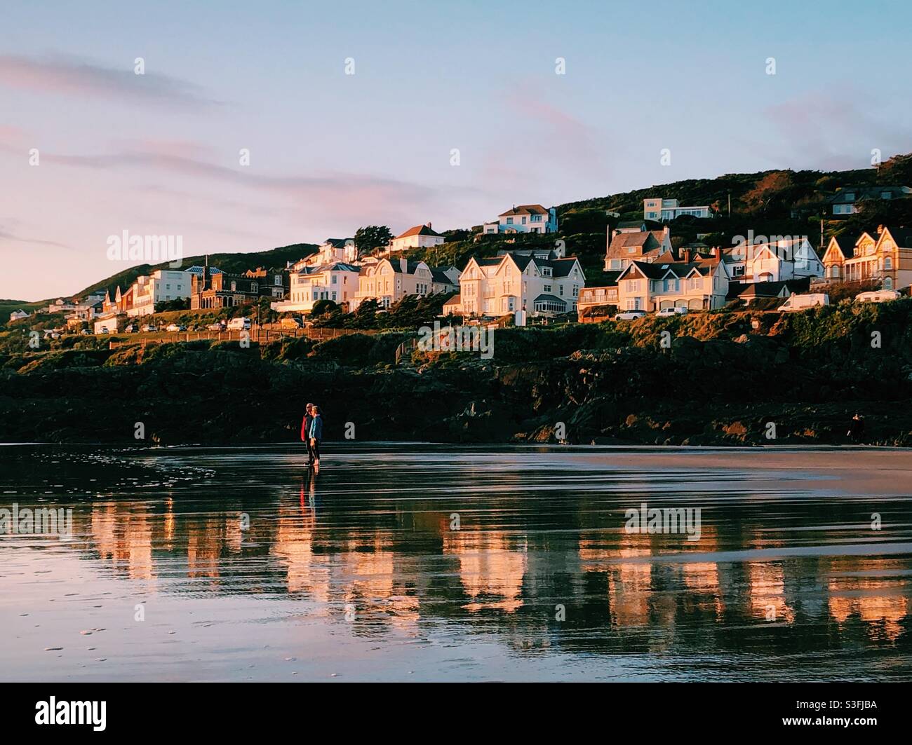 Houses on a hill in Ifracombe, Devon, reflected on the beach - Smartphone Captured Stock Image