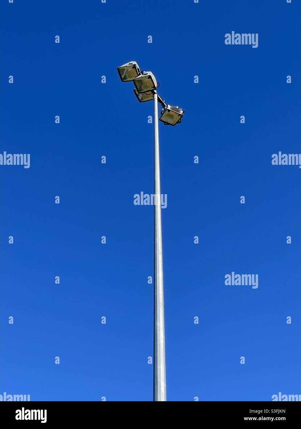 Light tower on a sports ground against blue sky - Smartphone Captured Stock Image