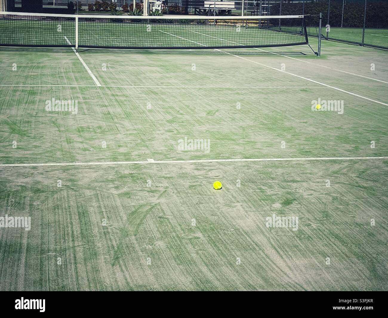 Two tennis balls on an empty tennis court - Smartphone Captured Stock Image