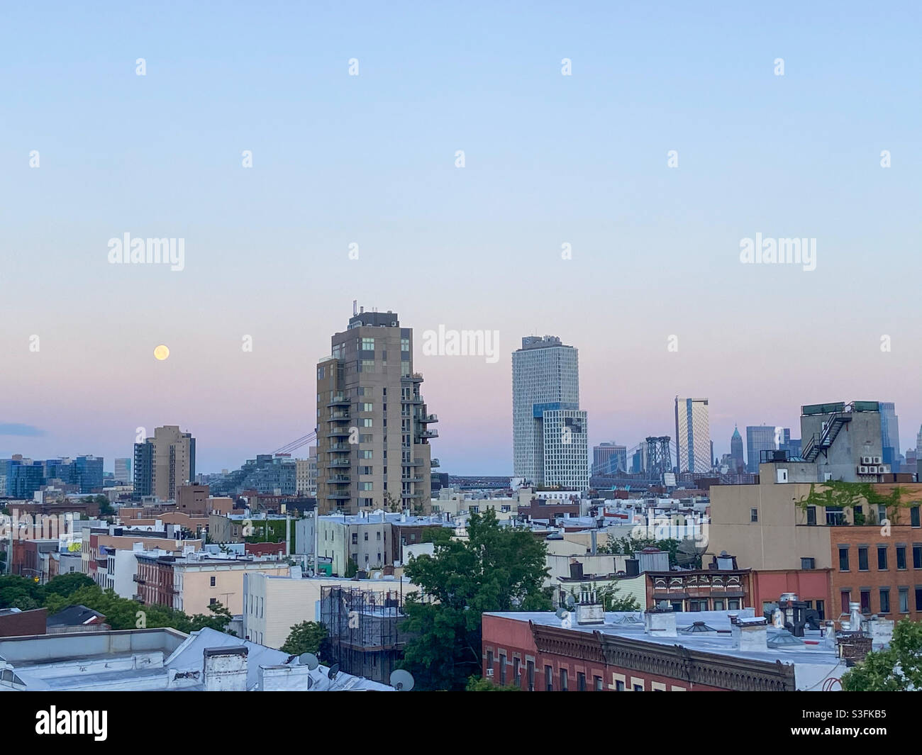 A full moon over Brooklyn, New York during sunrise on May 27, 2021. - Smartphone Captured Stock Image