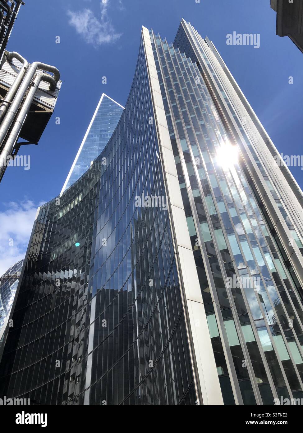Reflection of Lloyds of London in the Willis Building, City of London on a sunny day in May 2021 - Smartphone Captured Stock Image