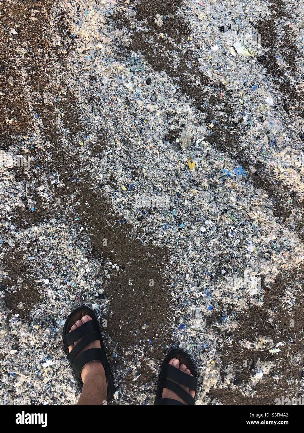 Crumbles of plastic causing pollution on the beach - Smartphone Captured Stock Image