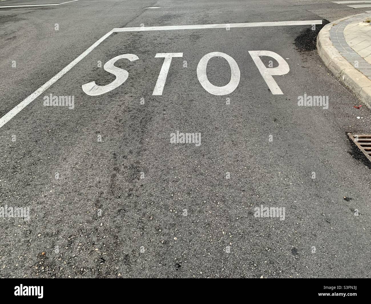 Stop sign painted in asphalt Stock Photo