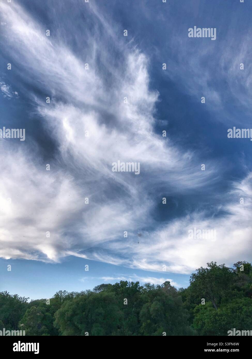 Angelic clouds fill the deep blue sky. Stock Photo