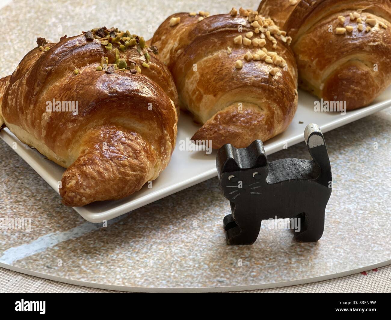 Croissants with a black toy wooden cat Stock Photo