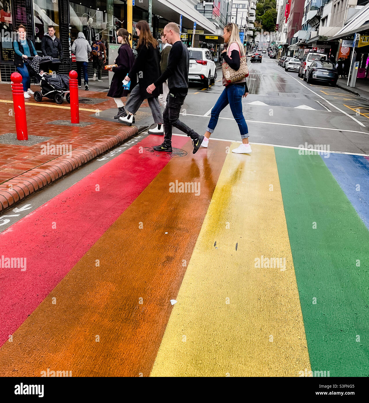 Pedestrians walk across the Rainbow Crossing in Cuba Street Wellington New Zealand Stock Photo