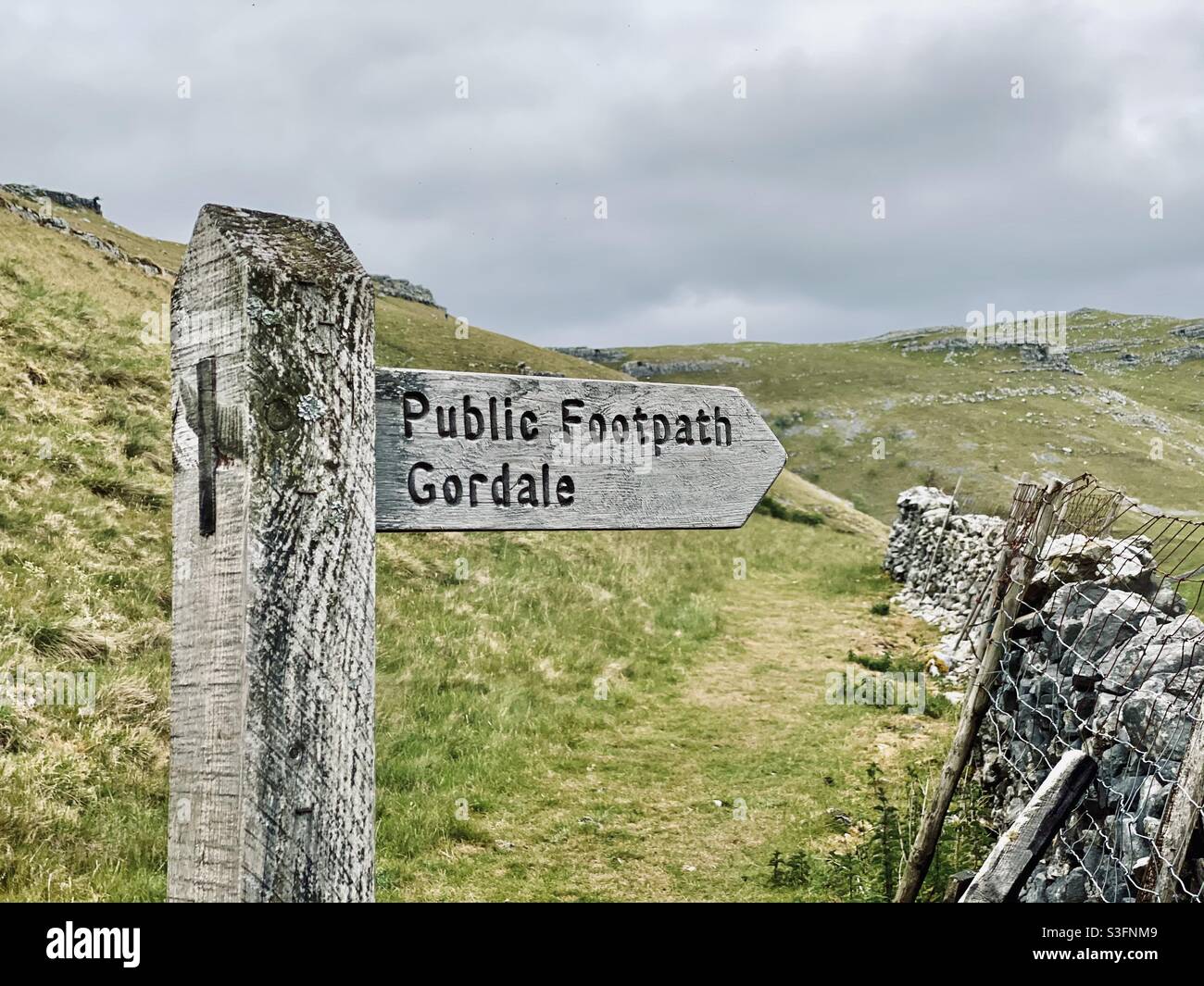 Scenic rural landscape with dramatic grey sky in Malham, Yorkshire Dales National Park, UK. Rolling hills and green pastures with dry stone walls. Hill walking - Smartphone Captured Stock Image