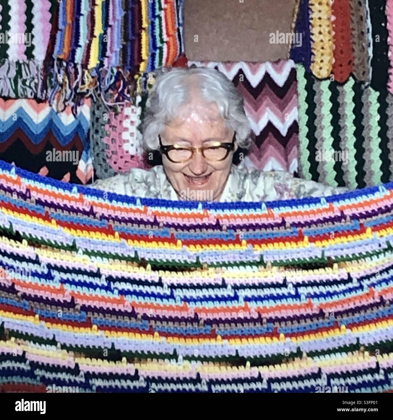 Smiling Elderly woman with crochet blanket she’s made at state fair ...