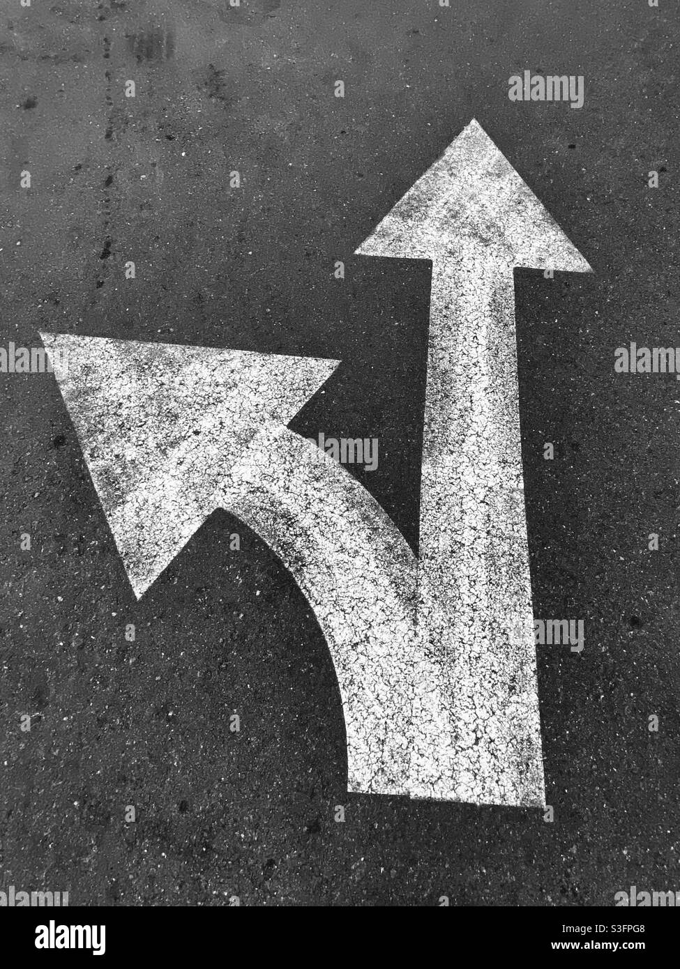 White directional arrows pointing up and left,in black and white - Smartphone Captured Stock Image
