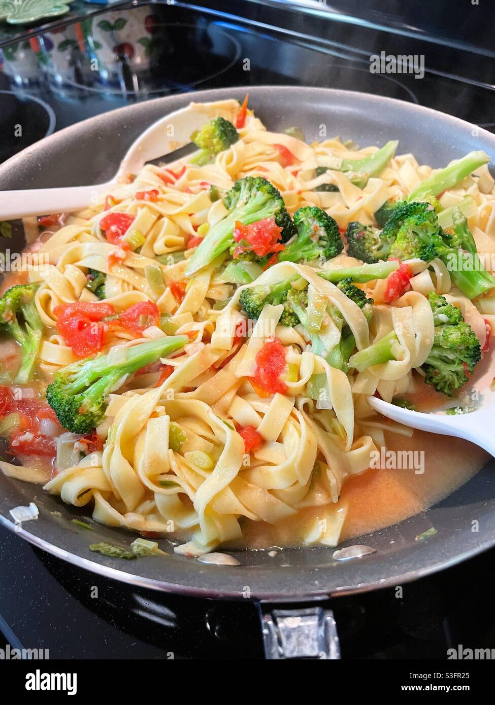 Close up of a skillet cooking pasta Primavera, USA - Smartphone Captured Stock Image