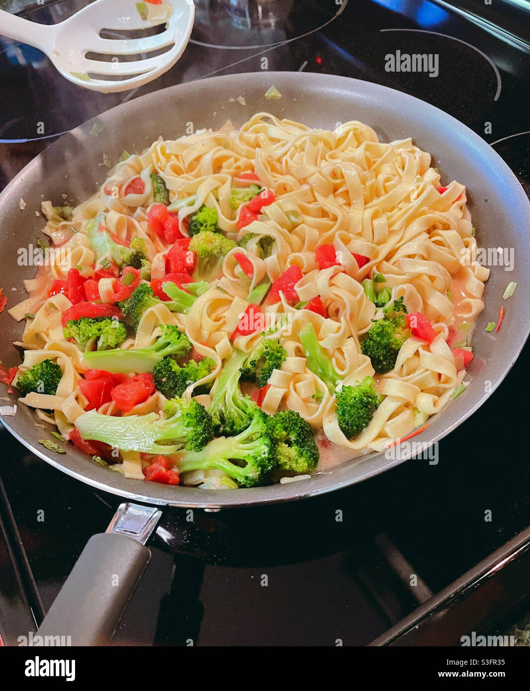 Pasta being sautéed on a residential range, USA - Smartphone Captured Stock Image