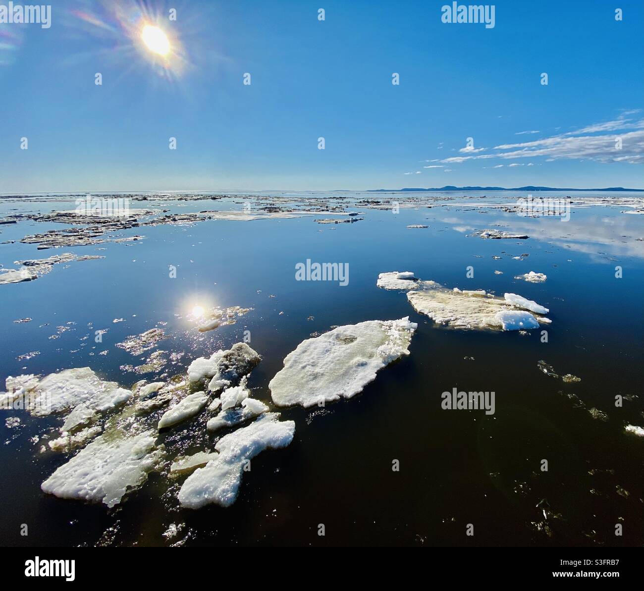 Melting ice floes in Kotzebue Sound from the annual spring break up of the sea and river ice in the Alaskan Arctic. Cape Krustenstern in background. - Smartphone Captured Stock Image