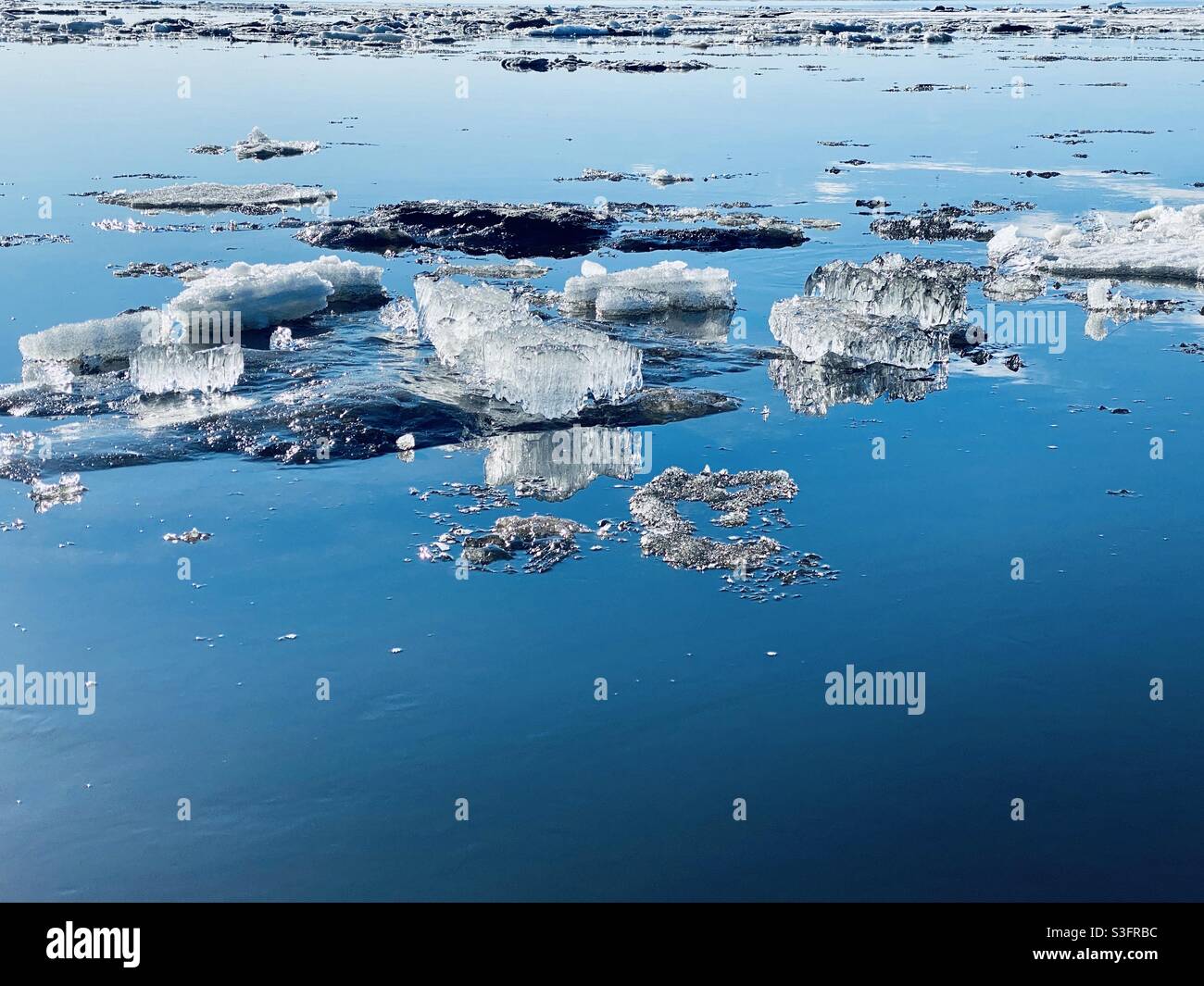 Melting ice floes and crystals in Kotzebue Sound from the annual spring break up of the sea and river ice in the Alaskan Arctic. Kotzebue, Alaska, USA - Smartphone Captured Stock Image