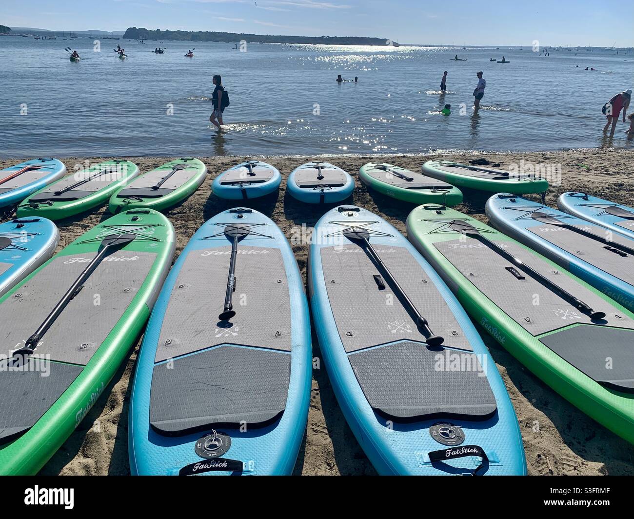 Paddle boards lined up at the beach in Poole Stock Photo