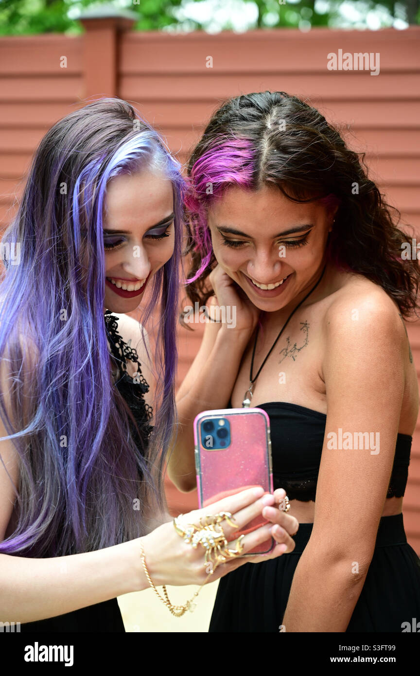 Pretty girls using technology, smiling, looking at iPhone - Smartphone Captured Stock Image