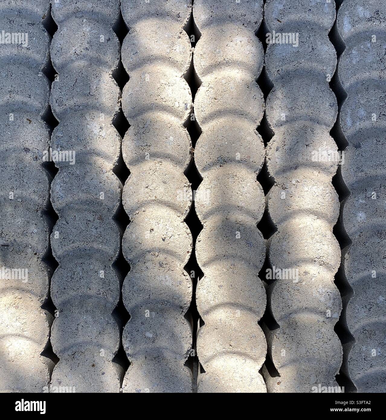 Texture and pattern from stack of pre-cast concrete garden border pieces. - Smartphone Captured Stock Image