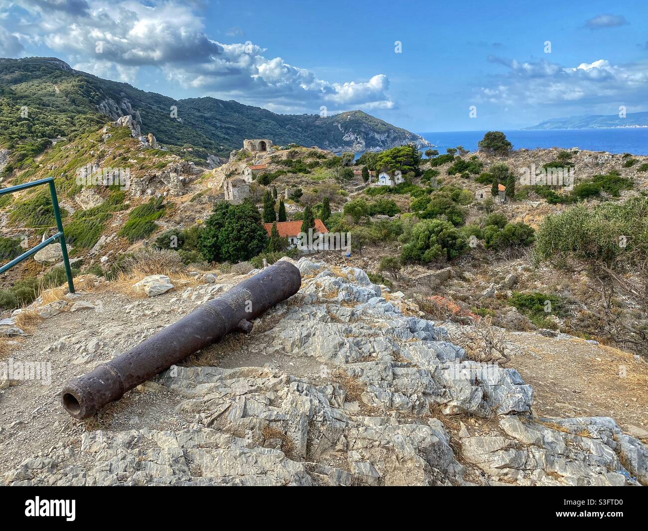 View at Kastro fortress ruins with an old cannon in the foreground and sea in the background on Skiathos island, Greece. - Smartphone Captured Stock Image