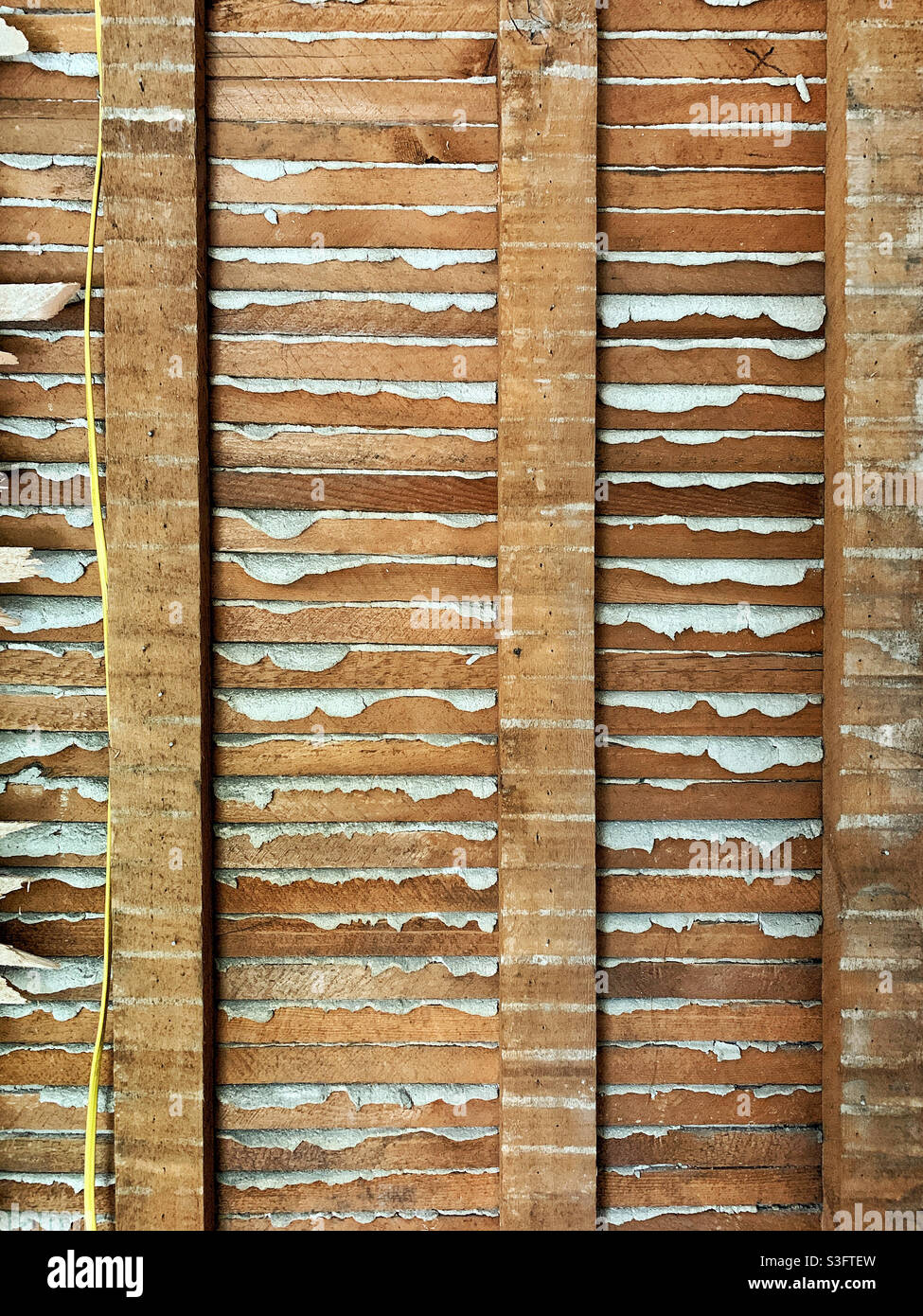 Interior wall of old house showing plaster and lath construction Stock Photo