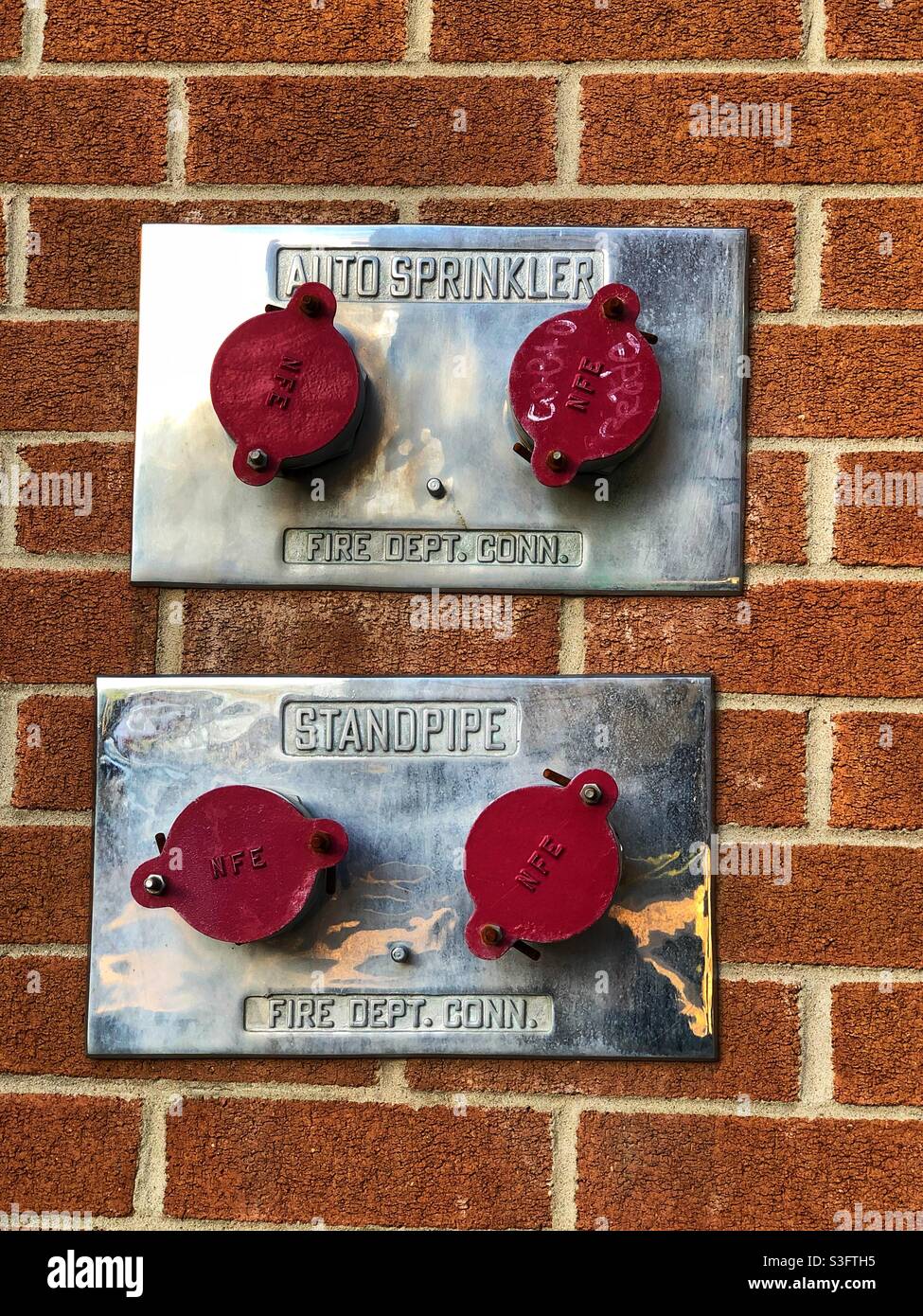 Auto sprinkler and standpipe connectors on the brick wall, Ottawa, Canada, May 2021 - Smartphone Captured Stock Image