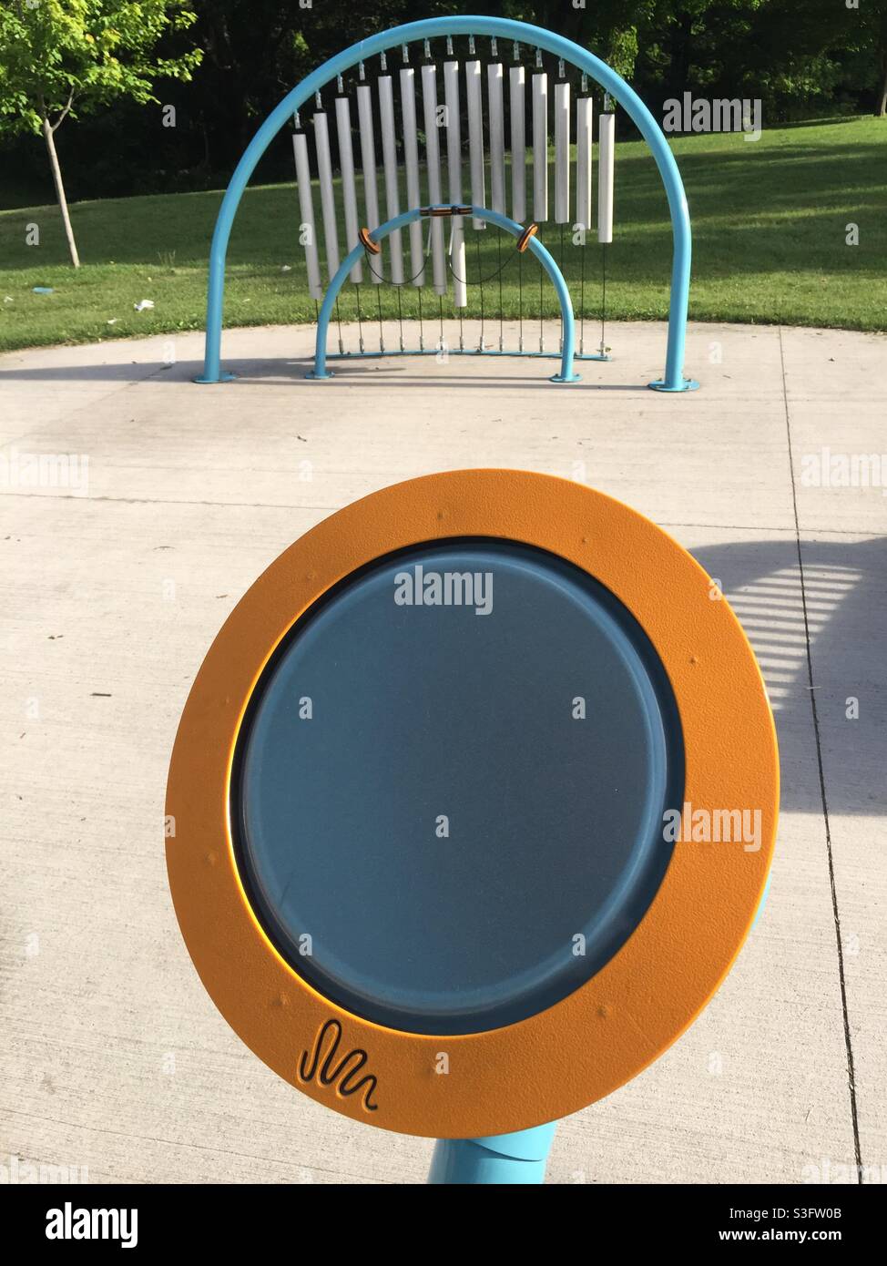 A drum and  a Marimba in a children’s corner of a large public park, Ontario, Canada. Geometry of music. Circles, arches, pipes. - Smartphone Captured Stock Image
