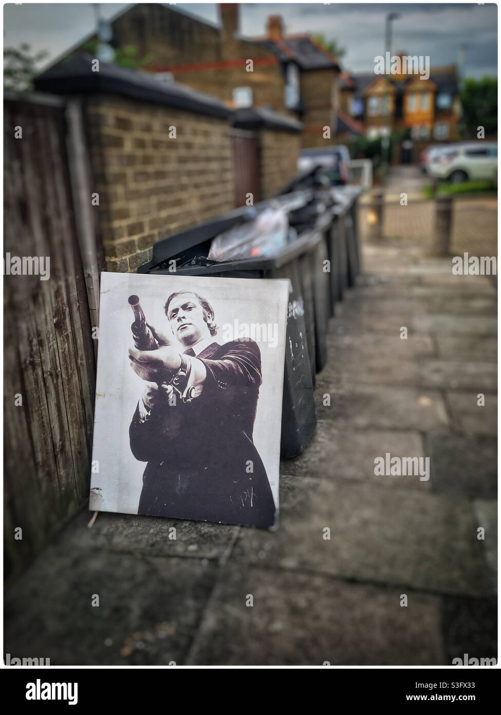 Michael Caine art canvas dumped by bins - Smartphone Captured Stock Image