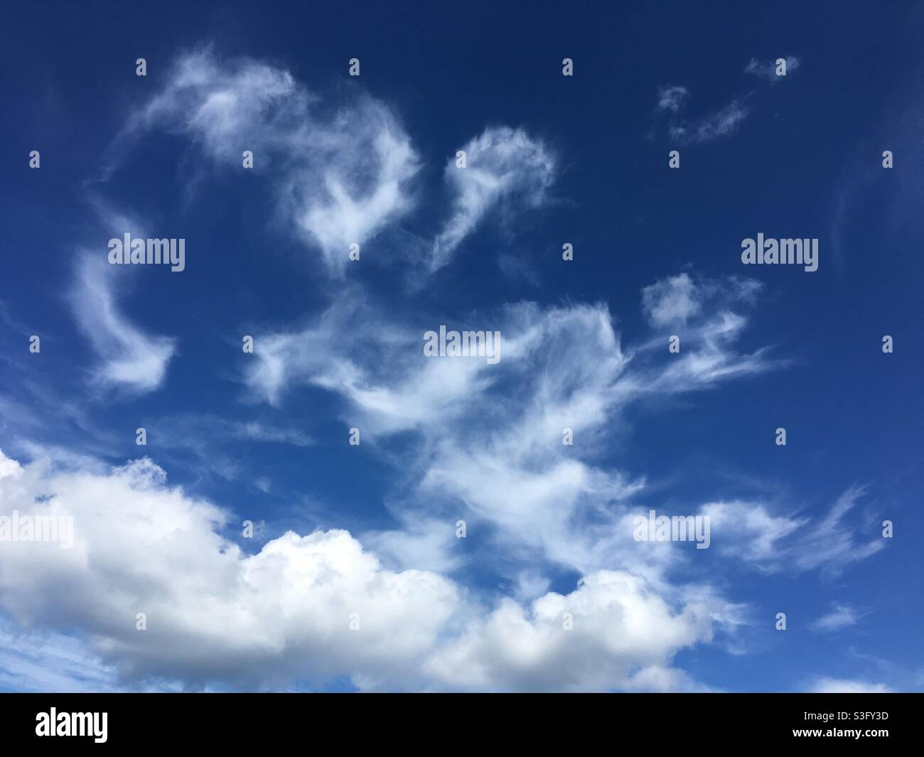 White Wispy clouds against deep blue sky - Smartphone Captured Stock Image