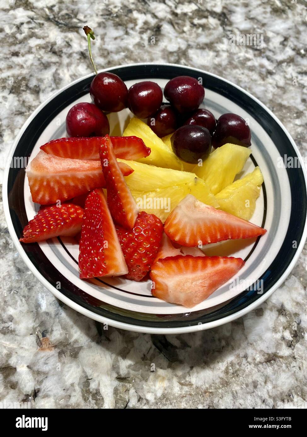 Strawberries, pineapples, and cherries in a bowl Stock Photo Alamy
