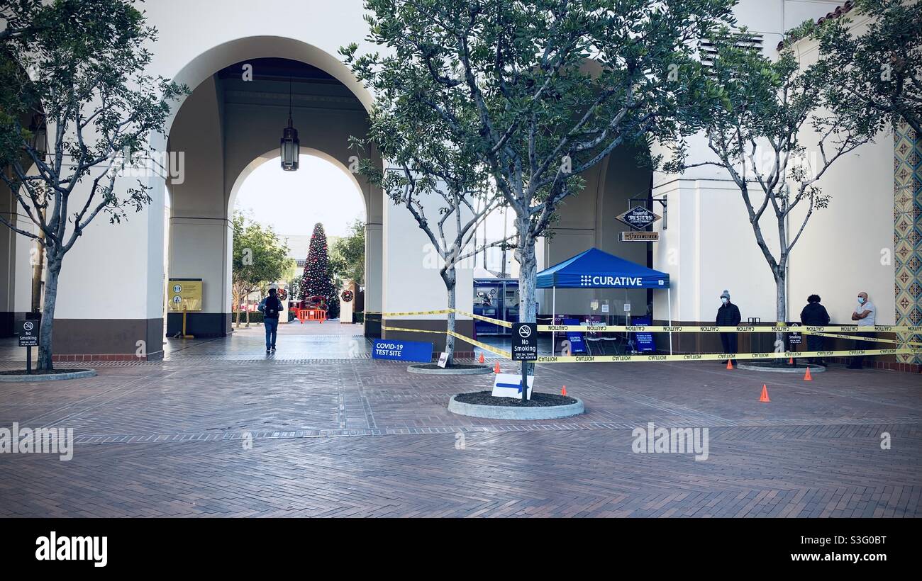 LOS ANGELES, CA, DEC 2020: wide view, people waiting for Covid-19 tests at Union Station in Downtown, Christmas Tree visible through archway Stock Photo