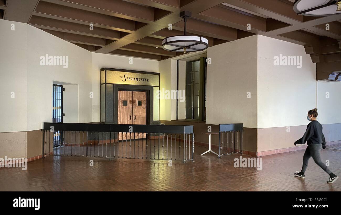 LOS ANGELES, CA, DEC 2020: person in mask, walking towards entrance of a closed bar at Union Station in Downtown - Smartphone Captured Stock Image