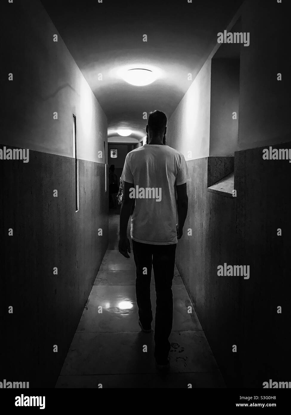 Man walking down a corridor Stock Photo