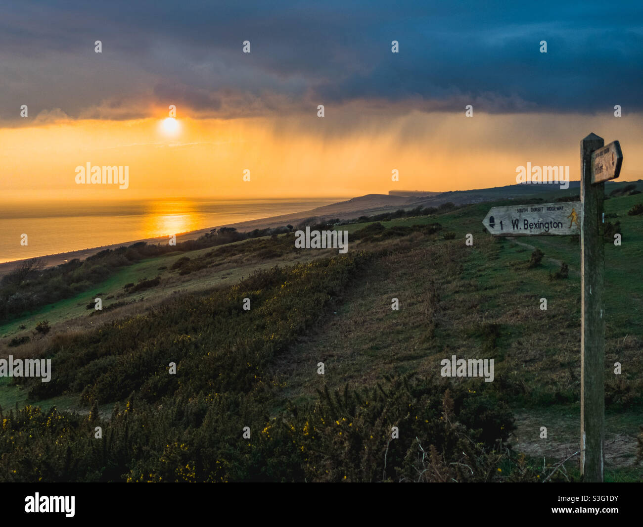 Sunset and rainstorm on the West Dorset coast near West Bexington Stock Photo