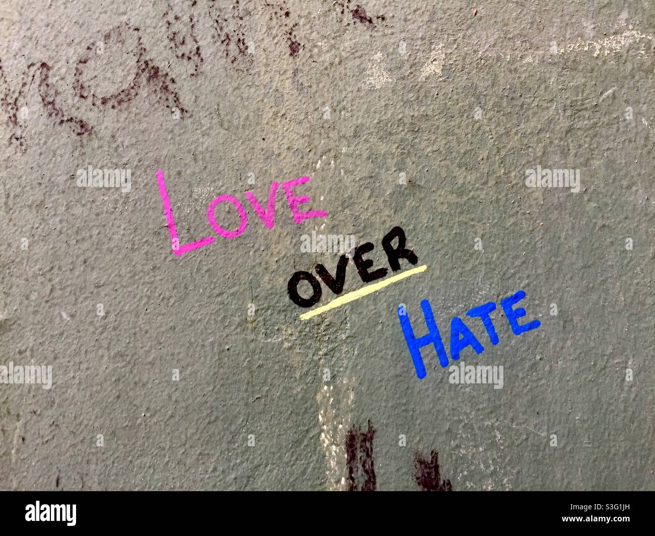 Timeless, and timely, graffiti on a concrete wall, Ontario, Canada. Traces of earlier writings. Bold message. Three four-letter words. - Smartphone Captured Stock Image