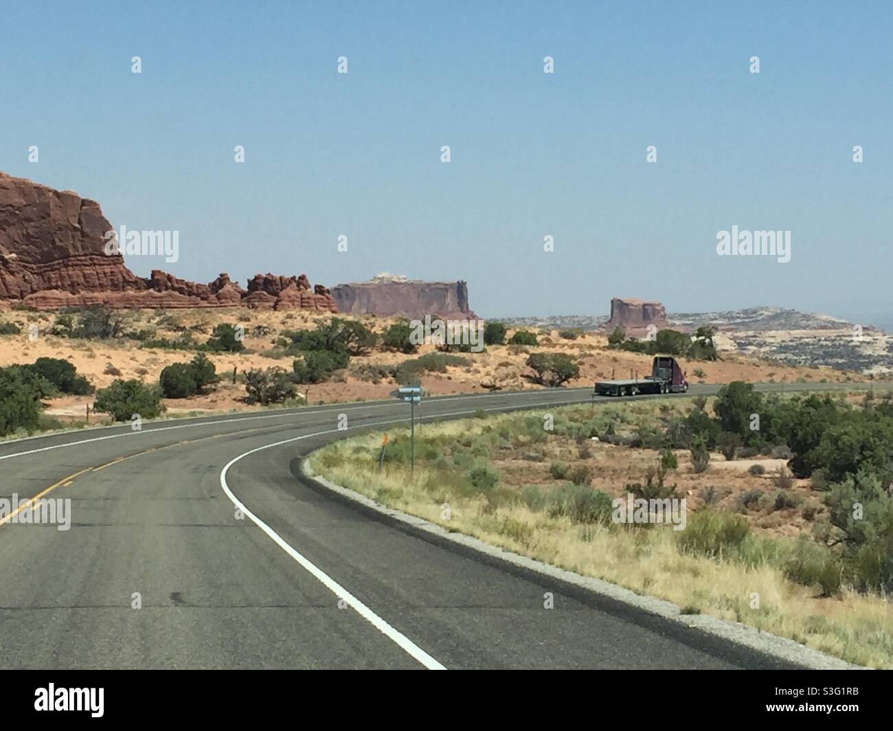 Long road in Northern Arizona and finally a curve in the road. Stock Photo