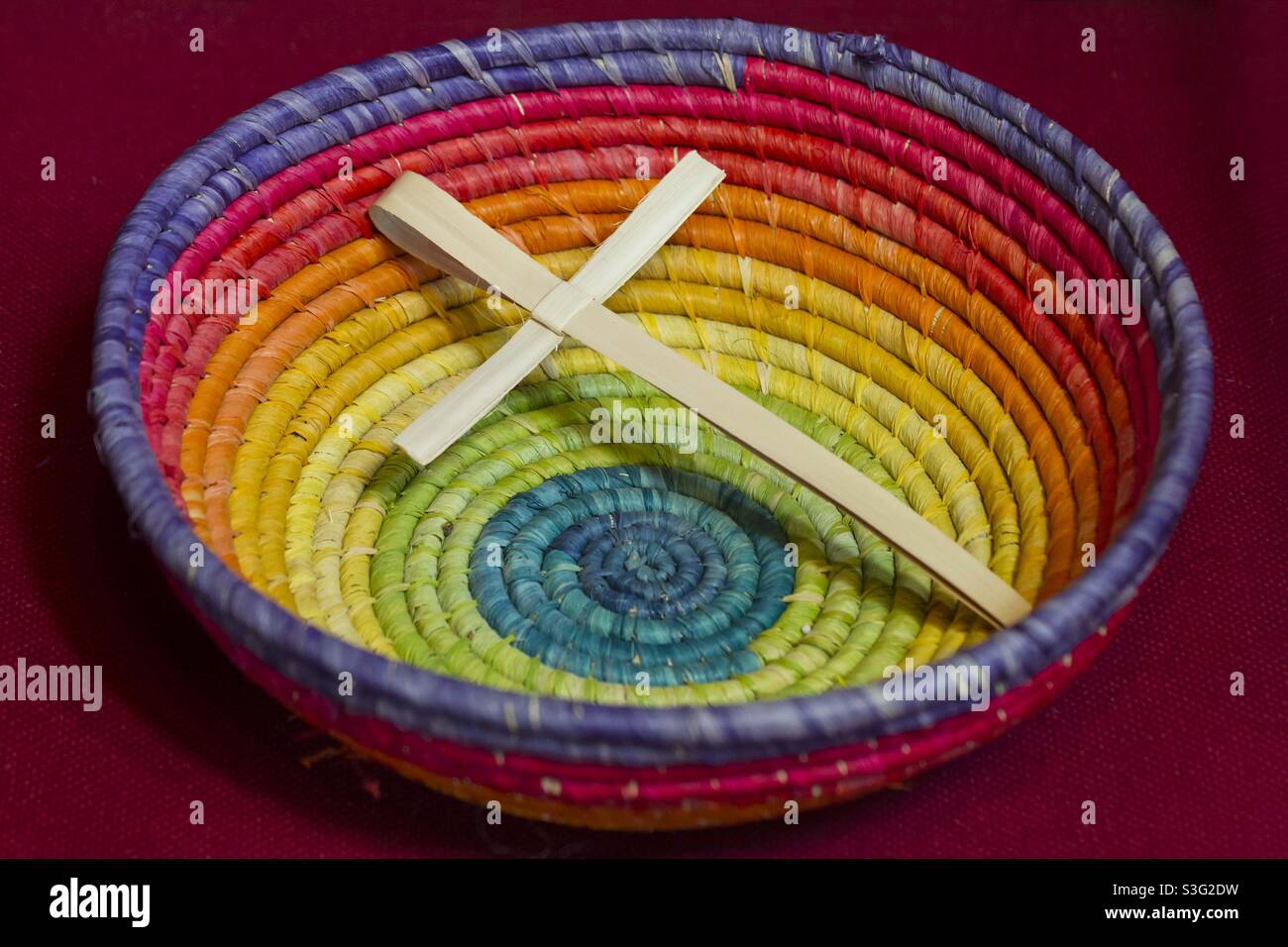 Palm Sunday cross in a rainbow coloured wicker bowl - Smartphone Captured Stock Image