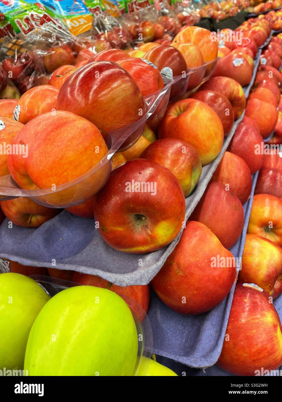 Cardboard pallets of fresh apples for sale in a grocery store produce
