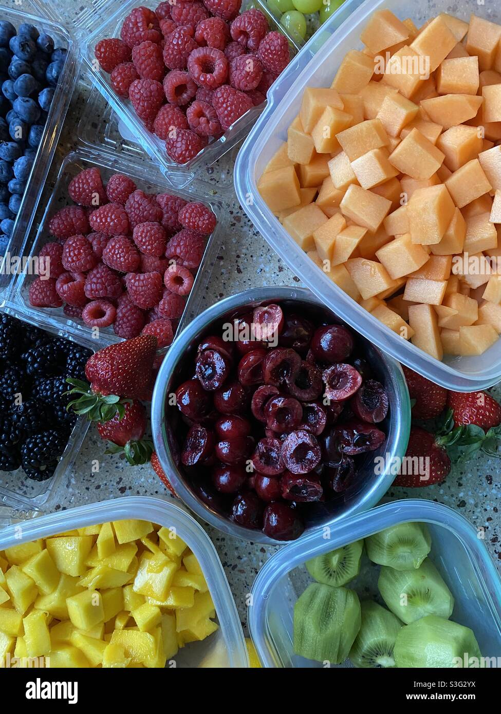 Mixed fruit in separate containers. Cantaloupe, cherries, mango, kiwi, raspberries, strawberries, blueberries, grapes. - Smartphone Captured Stock Image
