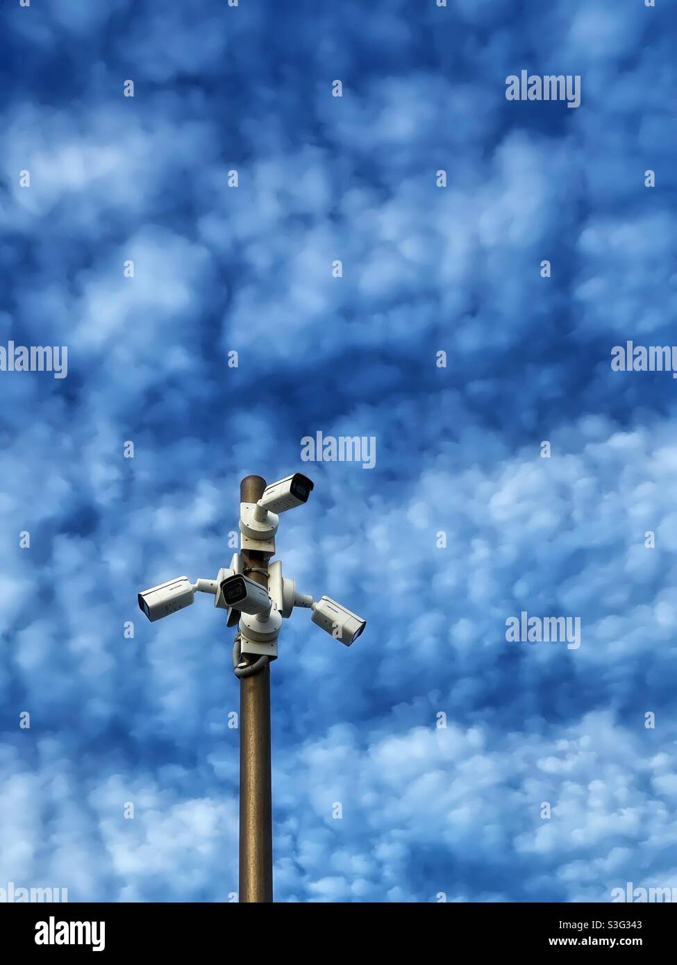 Surveillance camera against blue sky and puffy clouds - Smartphone Captured Stock Image