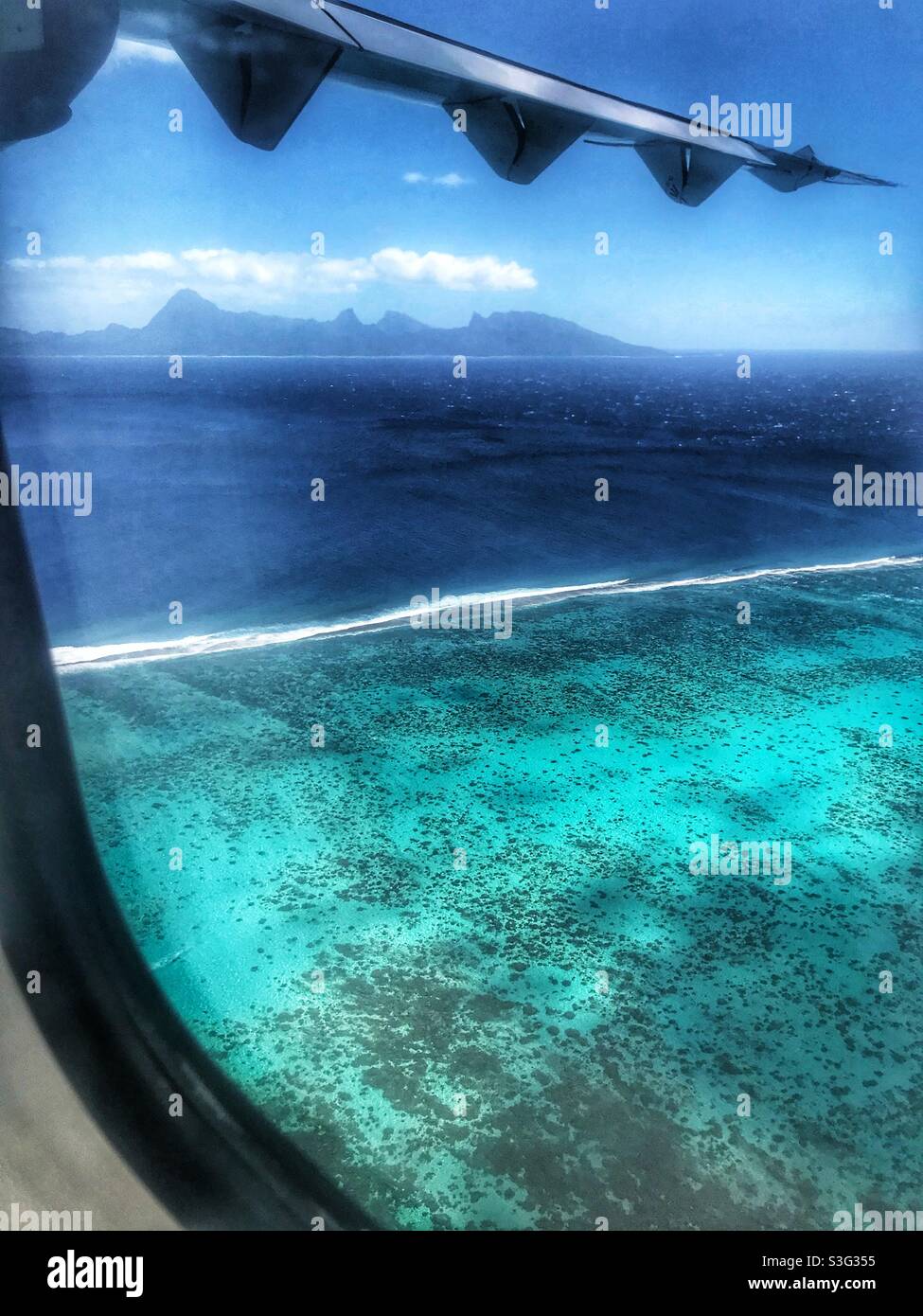 View of Moorea over the Tahiti lagoon from a flight leaving Pape’ete - Smartphone Captured Stock Image