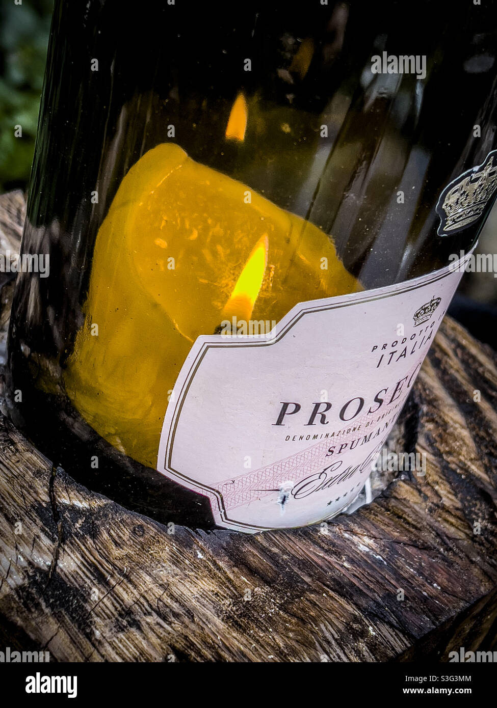 Candle burning inside Prosecco glass bottle - Smartphone Captured Stock Image