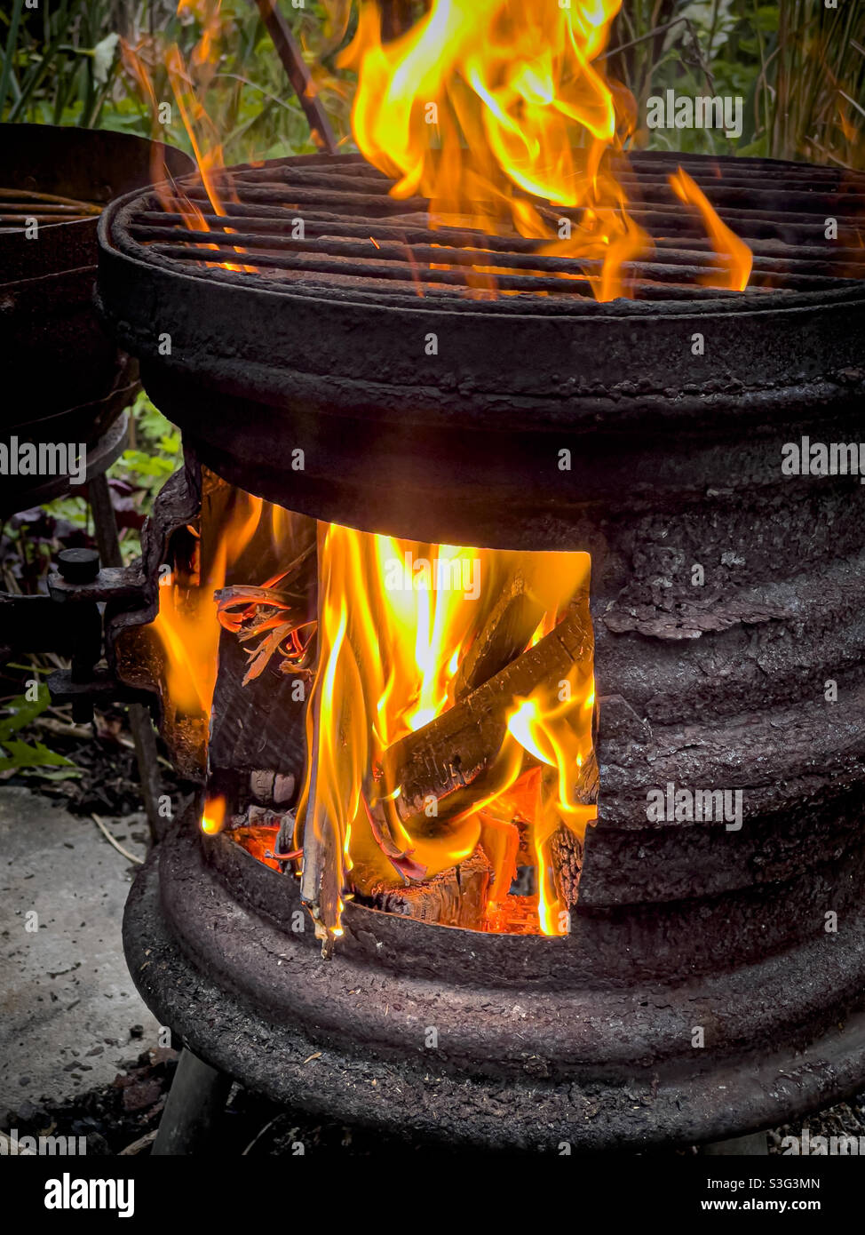 Flames in log burner made from old recycled car wheels - Smartphone Captured Stock Image