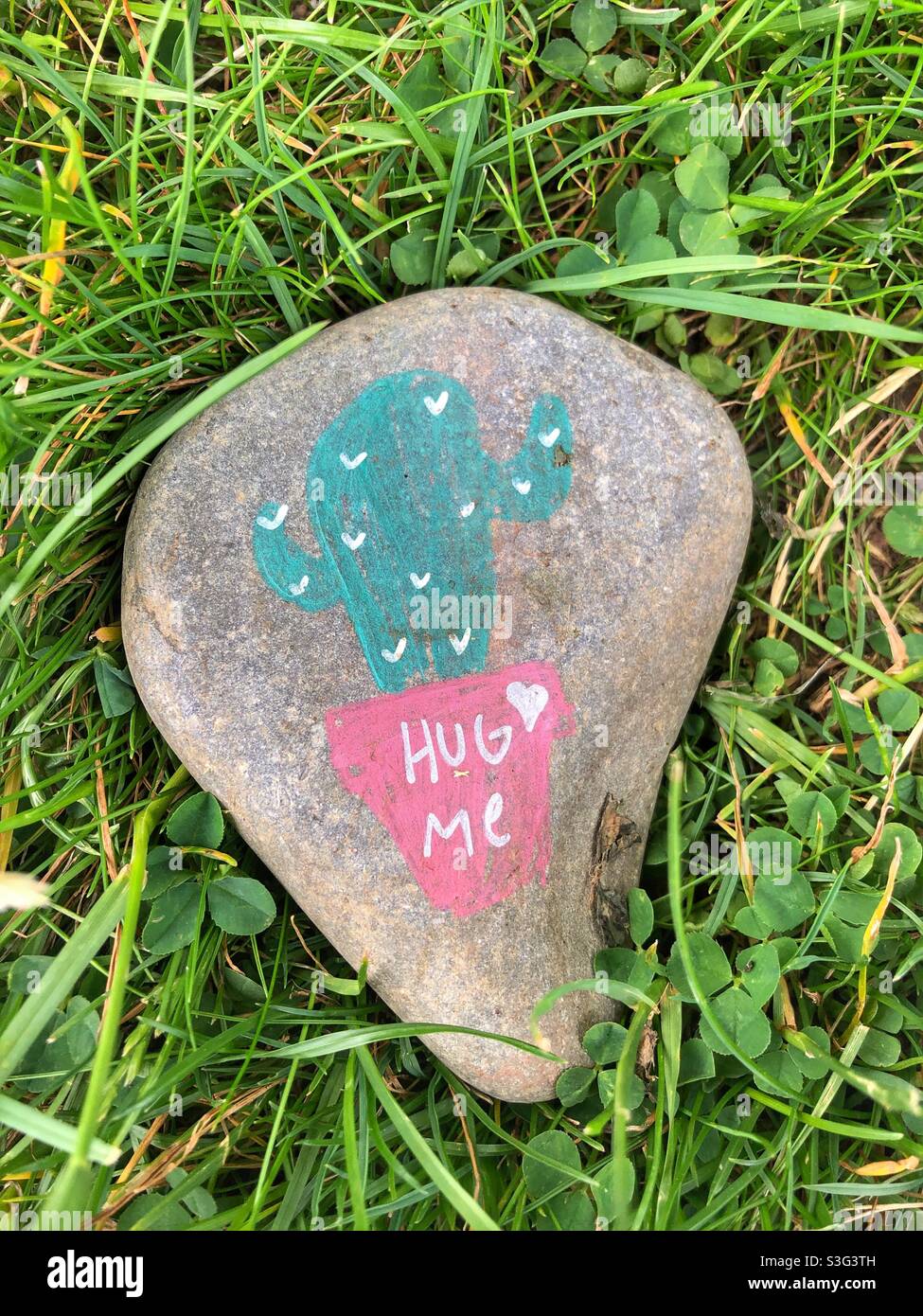 A painted stone with the words hug me. - Smartphone Captured Stock Image