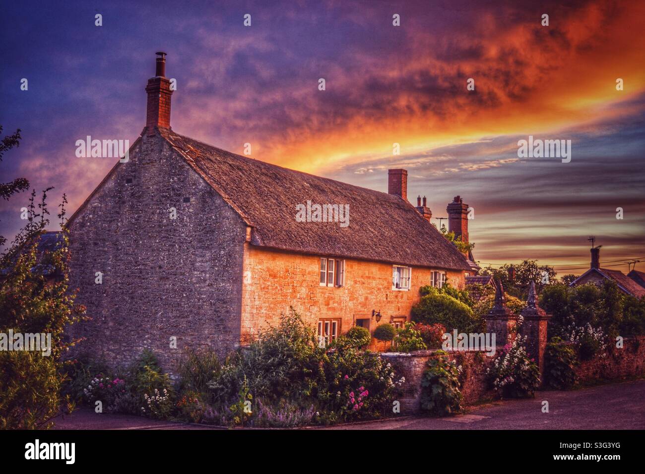 Thatched cottage at sunset in an English rural village, Somerset, U.K. Stock Photo
