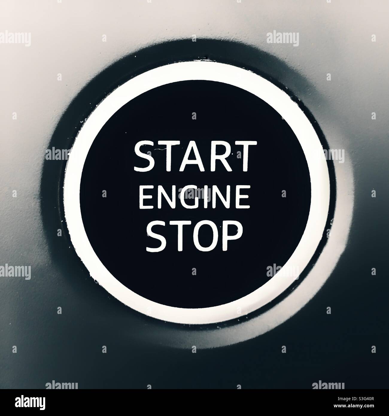 A motor car engine start and stop button in black-and-white - Smartphone Captured Stock Image