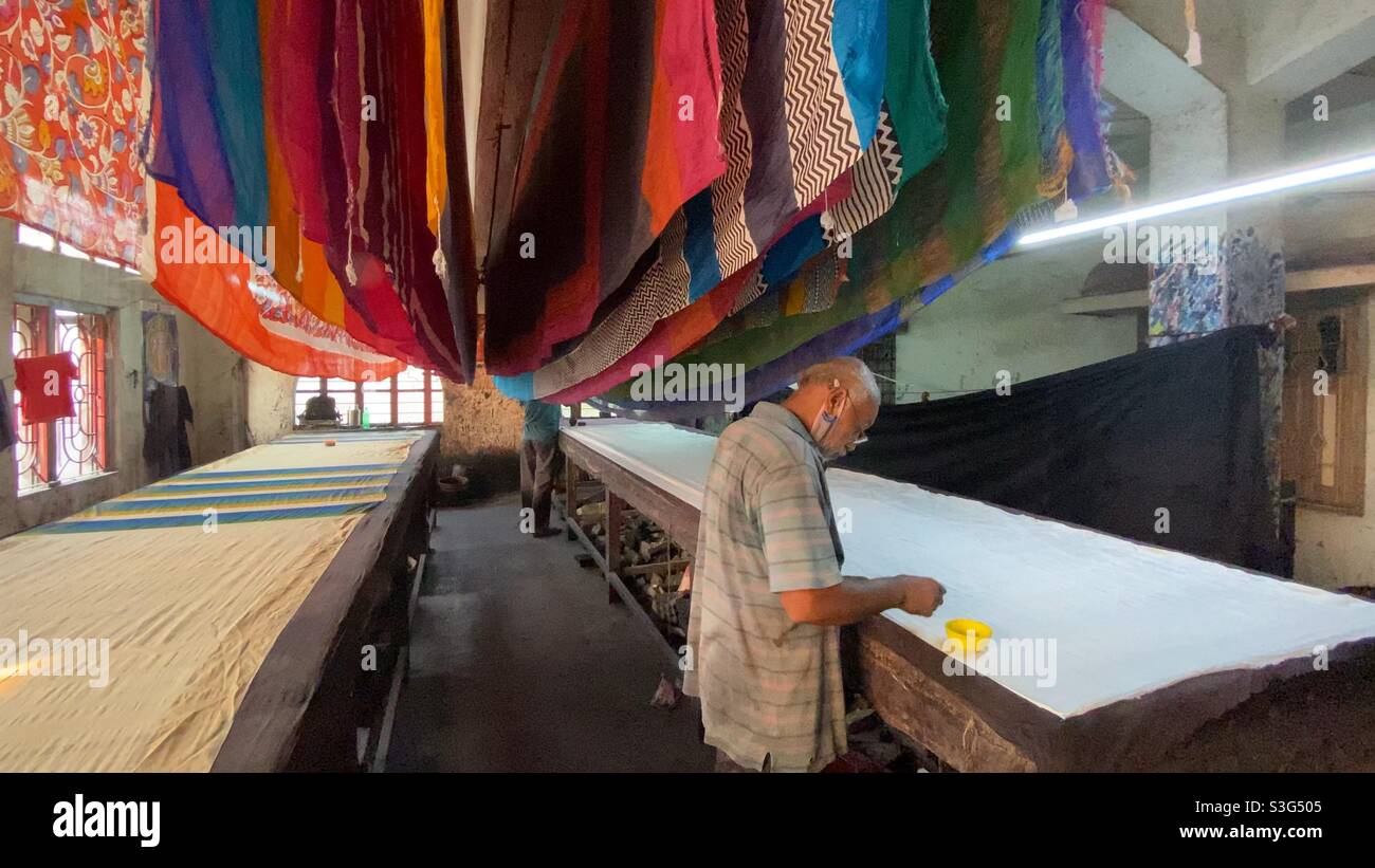 A man preparing colour dying to sari in an industry - Smartphone Captured Stock Image