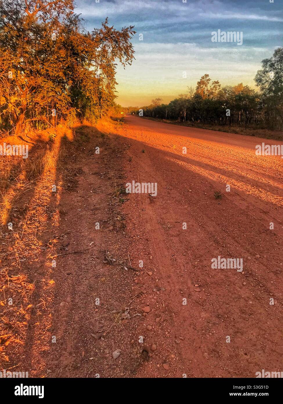 Late afternoon shadows on a red dirt road in Kakadu National Park, Northern Territory, Australia Stock Photo
