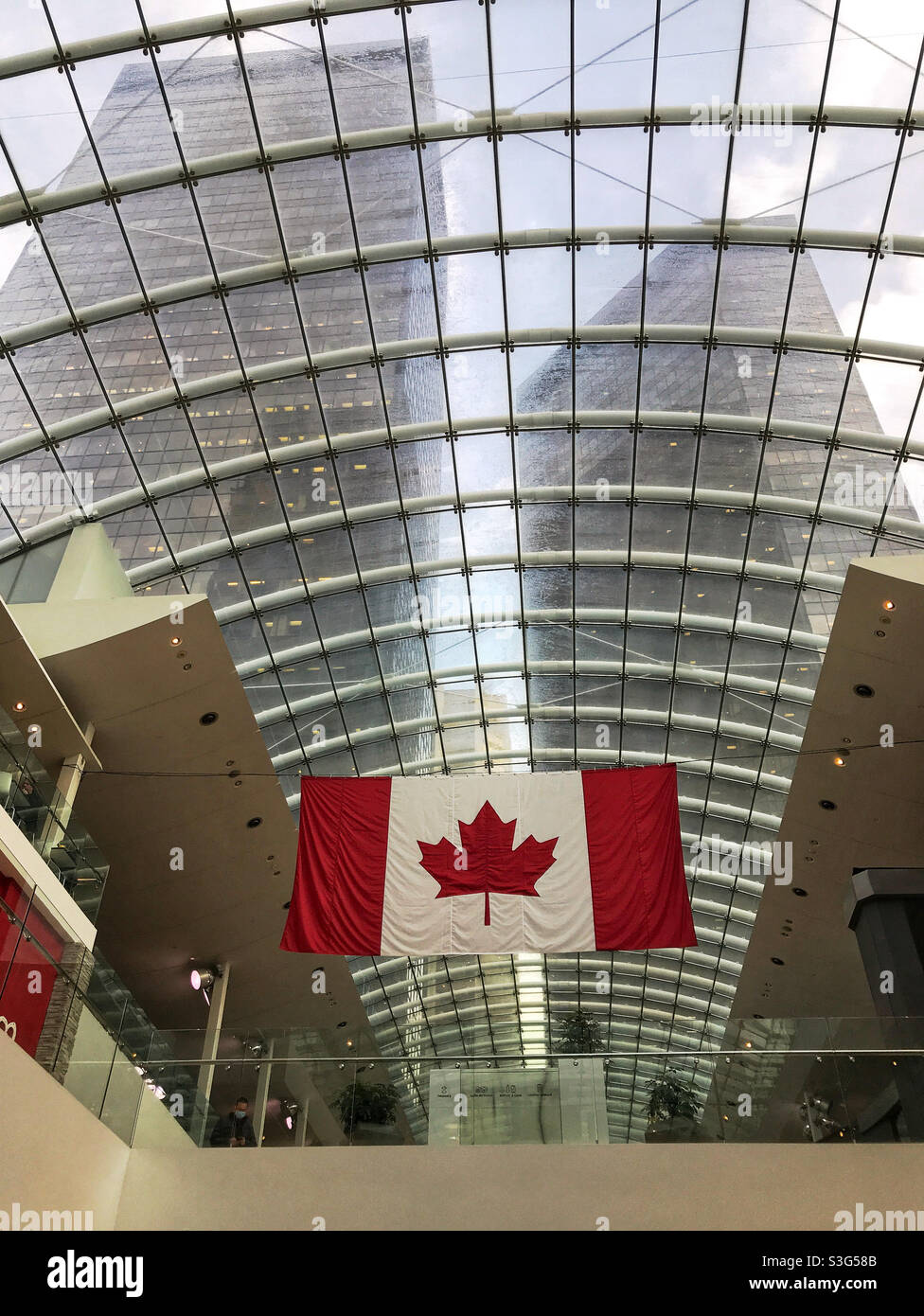 The Canadian flag hanging from the glass ceiling of The Core shopping centre. Downtown Calgary, Alberta, Canada. Stock Photo